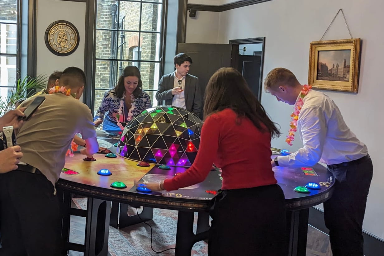 A group of colleague at a team building event playing a reaction game together.